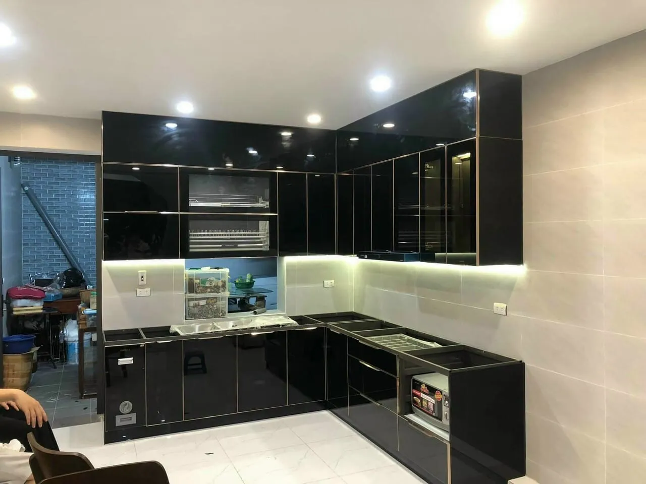 Tủ bếp khung inox cánh Acrylic đen bóng gương, mặt đá trắng Carrara