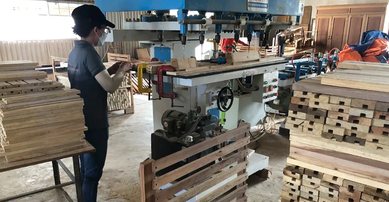 Hình ảnh nhân viên đang xử lý chi tiết gỗ trong xưởng sản xuất ghế gỗ bập bênh