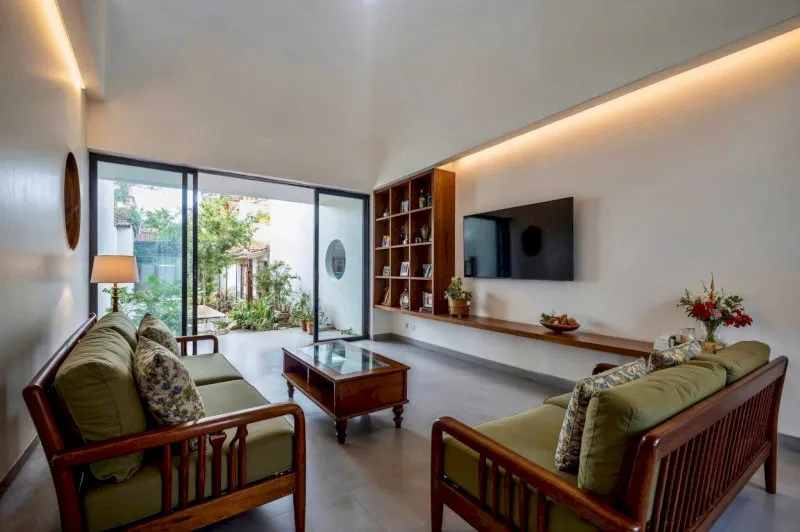 Mẫu phòng khách đẹp cho nhà cấp 4 có bàn ghế gỗ truyền thống đặt giữa không gian, tường sơn trắng, cửa sổ lớn đón gió trời