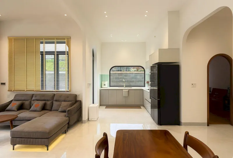 Nội thất gỗ mộc kết hợp sofa vải tối màu tạo nên sự hài hòa giữa nét truyền thống và phong cách hiện đại cho ngôi nhà