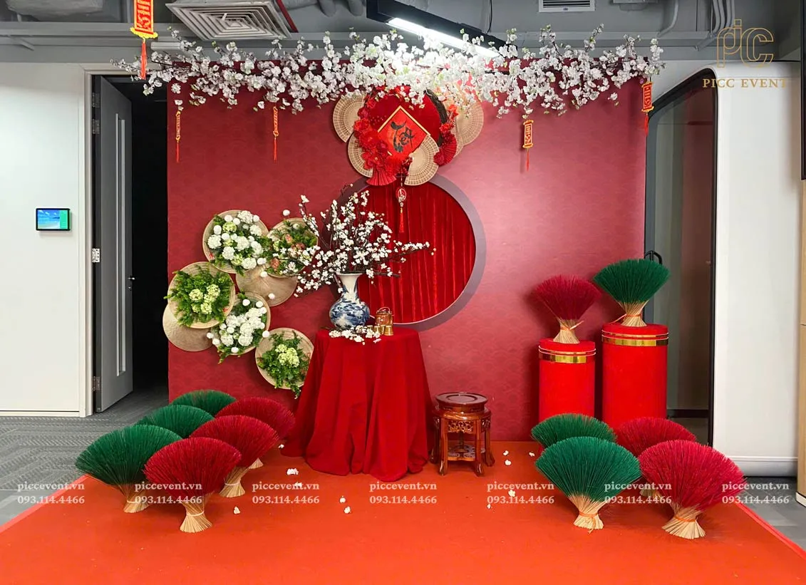 Không gian văn phòng được trang trí với dây kim tuyến, hoa giấy và backdrop tết